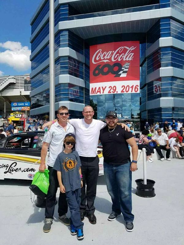 people in front of NASCAR race track