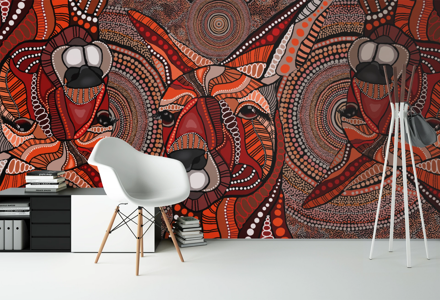 a white chair in front of a wall painted with aboriginal artwork