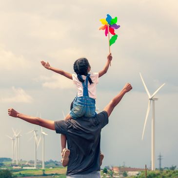 Dad and daughter in front of windmills