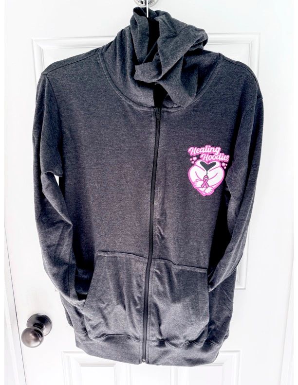 Dark gray zip-up hoodie with Healing Hoodies logo and pink ribbon.