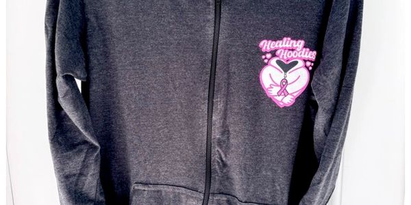Dark gray zip-up hoodie with Healing Hoodies logo and pink ribbon.
