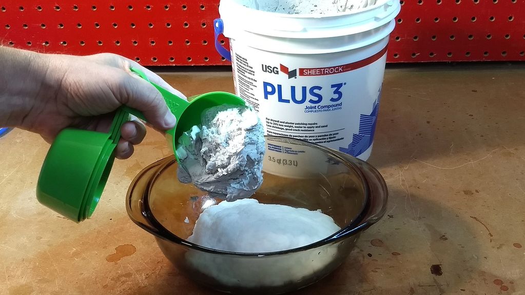 Adding joint compound to the bowl with the wet paper