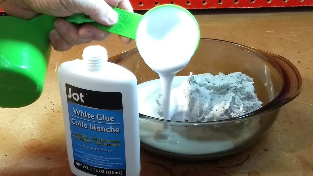 Pouring white glue into the bowl with the paper and joint compound