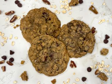 Three oatmeal chocolate chip cookies with pecans.