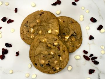 Three cookies with white chocolate chips and dried cranberries.