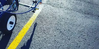 Showing a line being restriped with paint for a commercial parking lot.