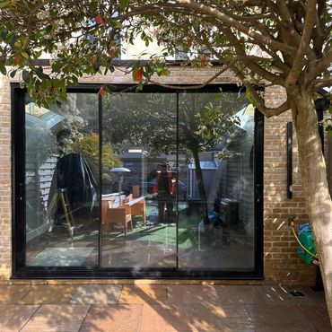 Full side to side extension in a terraced house with steel box frame for maximum opening and flat ro
