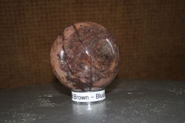 Very interesting brown sphere with deep fracturing that holds together. Bits of Azurite show in sphe