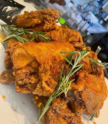 Crispy fried chicken garnished with rosemary.