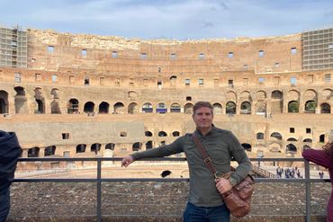 Man posing inside the ancient Colosseum in Rome.