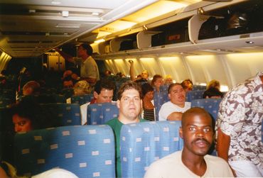 Passengers seated inside a commercial airplane cabin during a flight.