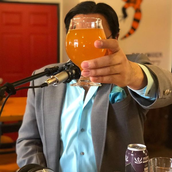 A colorful picture of The Classy Alcoholic at a microphone. His face is obscured by a hazy ale.