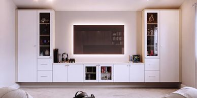 Modern living room with white cabinets, a wall-mounted TV, and a coffee table with VR equipment.