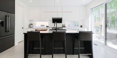 Modern kitchen with black and white contrast and large window.