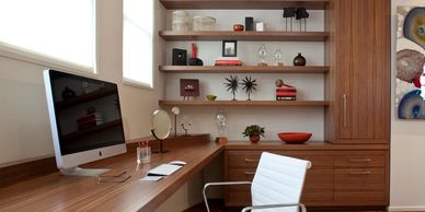 Modern home office with wooden furniture and a white chair.