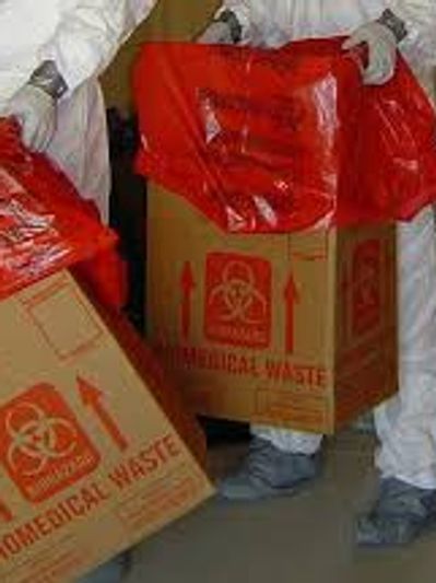 Hazmat technicians bagging up biohazardous waste and prepping it for disposal.