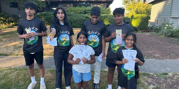 Group of kids holding papers outdoors.