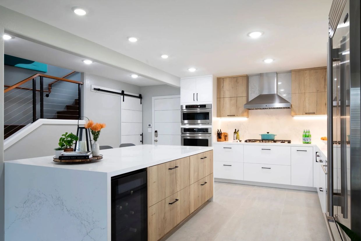 Modern kitchen with wood and white cabinetry and island.