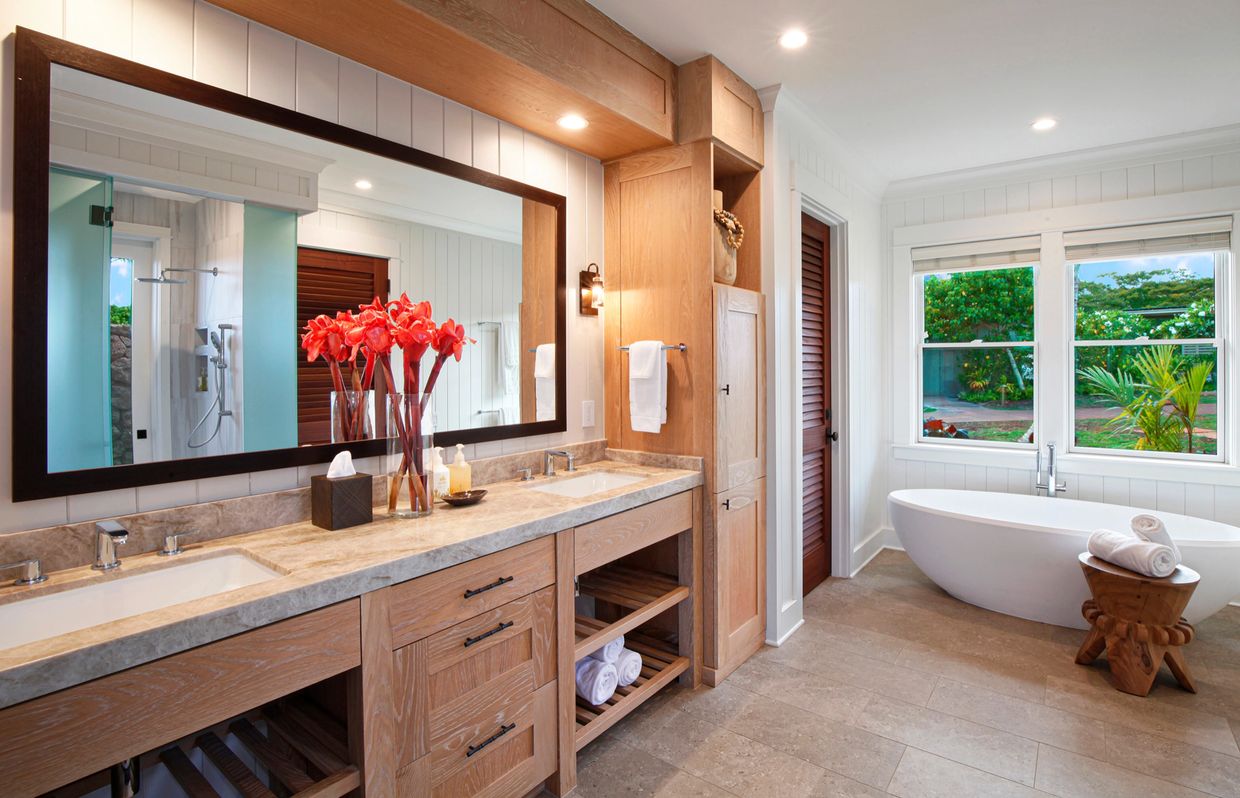 Modern bathroom with a large mirror and bathtub.