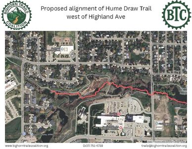 Aerial view of a suburban neighborhood with a red line marking a trail through a green area.
