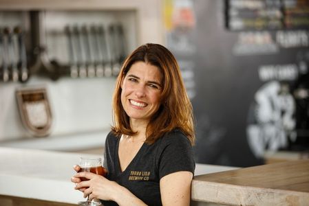 Jen Newman our CEO (headshot of her holding a beer)