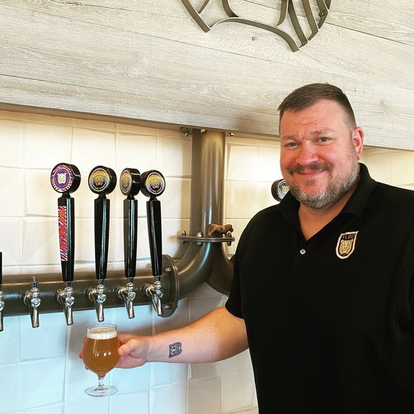 Image of Taproom Co-Captain, Josh Elias in the taproom holding a beer.