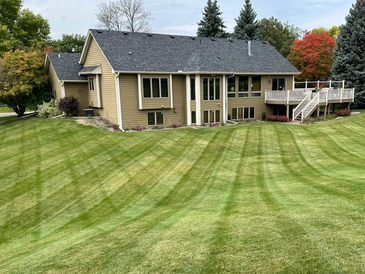 Picture of a lawn mowed by Your Outdoor Helper LLC with beautiful vibrant stripes.