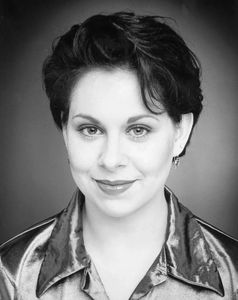 Black and white portrait of a smiling woman with short hair.