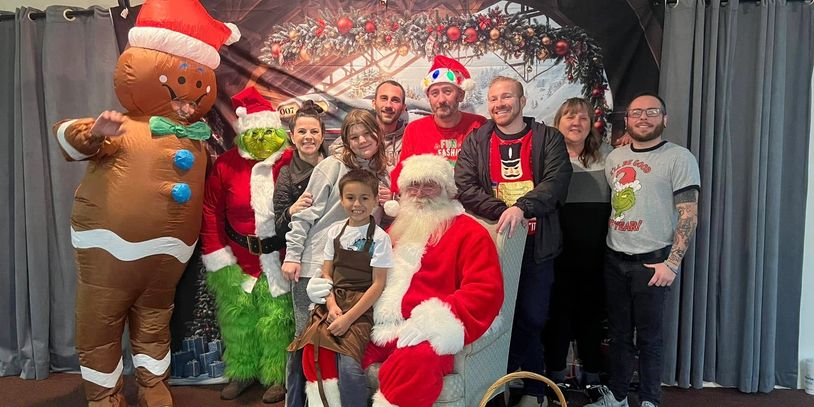 Group photo with Santa and festive characters.