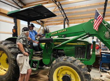 Men drink a beer with their old friend JOHN DEERE