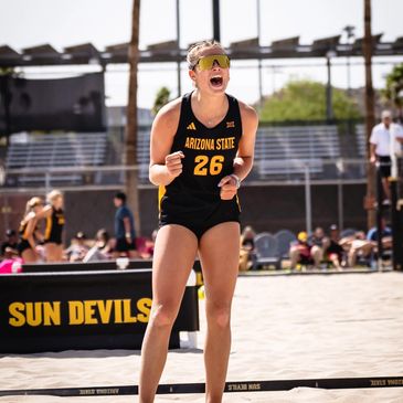 Arizona State beach volleyball player celebrates on the sand court.