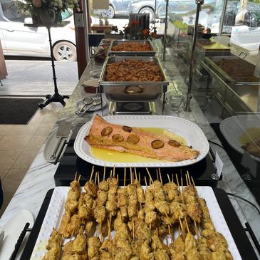 Buffet setup with grilled skewers, salmon, and pasta dishes for a private event at gastronomia fairfax
