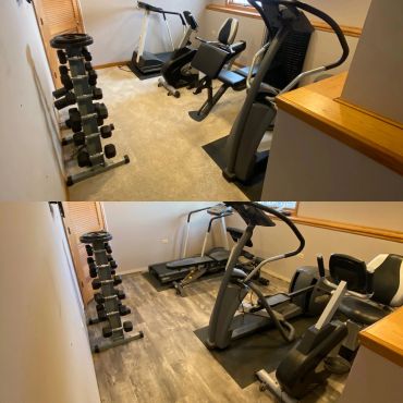 Home gym with dumbbells, treadmill, and exercise machines on wood flooring.