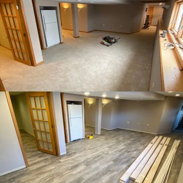 Basement room with new flooring and wooden door frames.