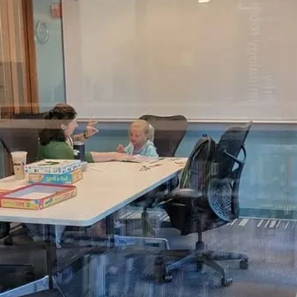 Kate Muldoon sitting at a table with a client doing a lesson.