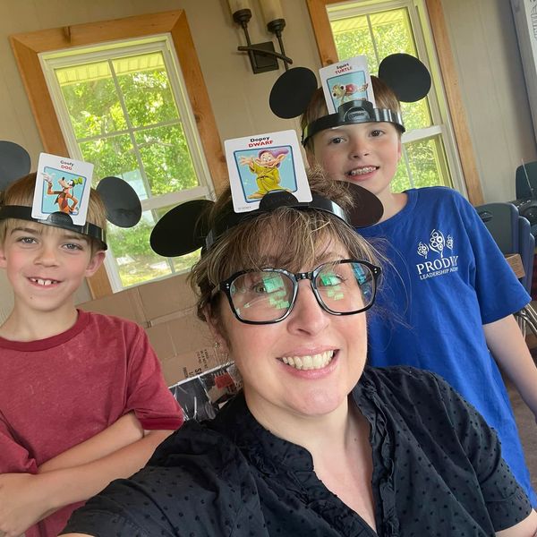 Kate Muldoon smiling with two clients while playing a game.