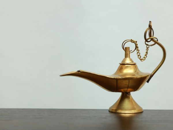 Antique brass oil lamp on a wooden surface.