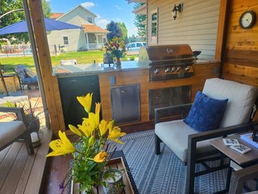 View from covered porch to outdoor kitchen, custom built - cedar wood & granite countertop. MDR
