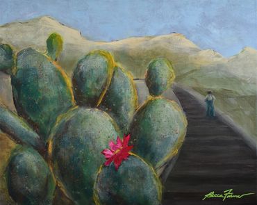 a cactus in bloom next to a railroad track heading off into the distance
