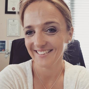 A smiling, highly quialified hypnotherapist