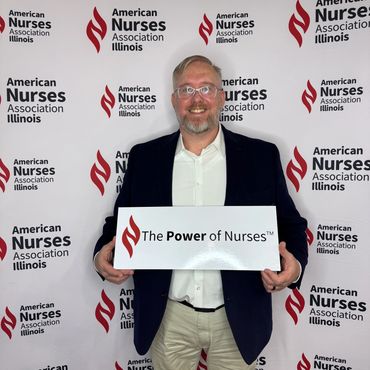 Man holding a sign promoting the power of nurses at an American Nurses Association Illinois event.