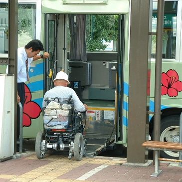 A pic of a person in a wheelchair getting into a bus.