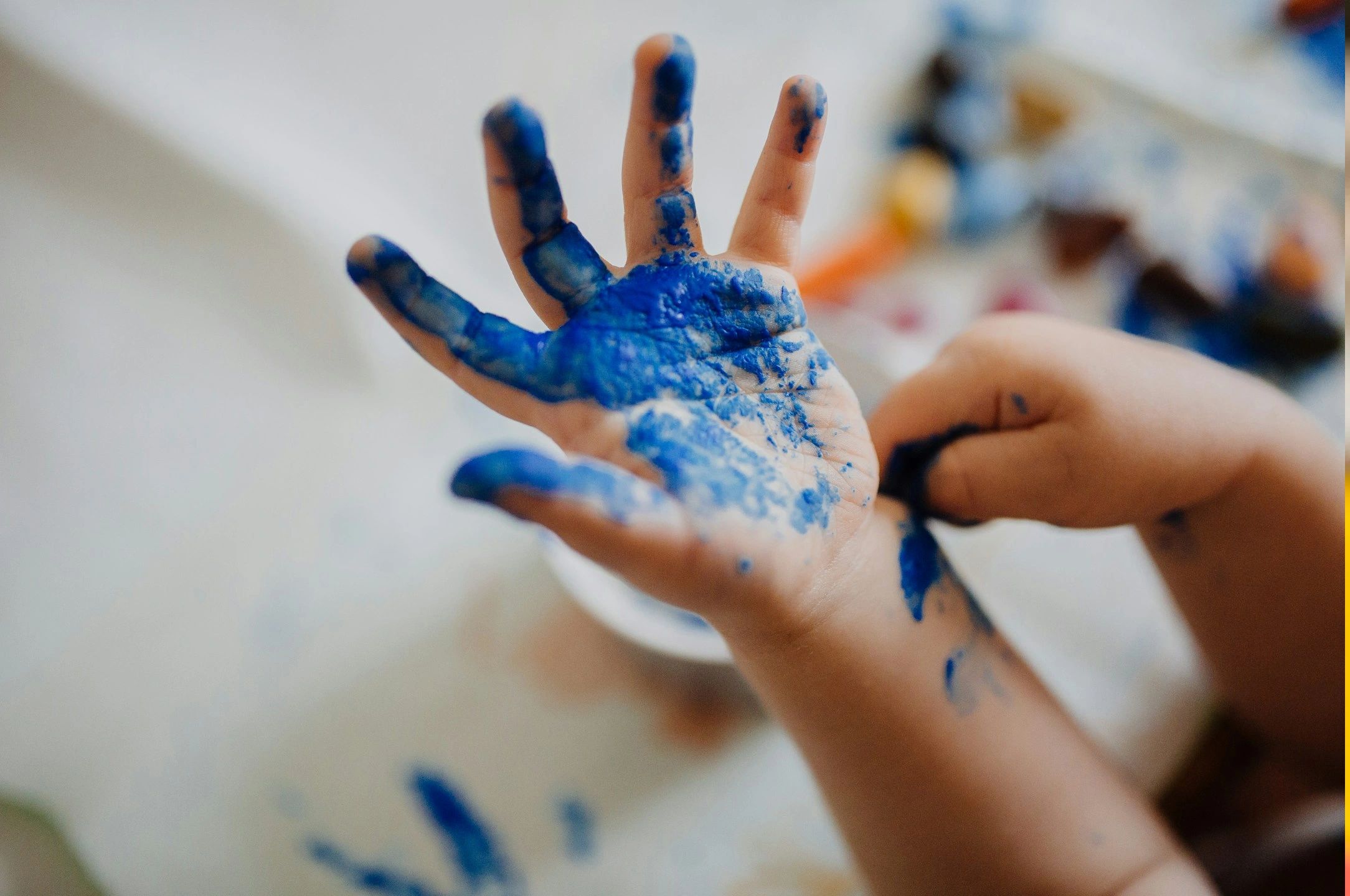 Close-up of a hand covered in blue paint.