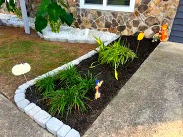 Black mulch bed trimmed with white brick pavers