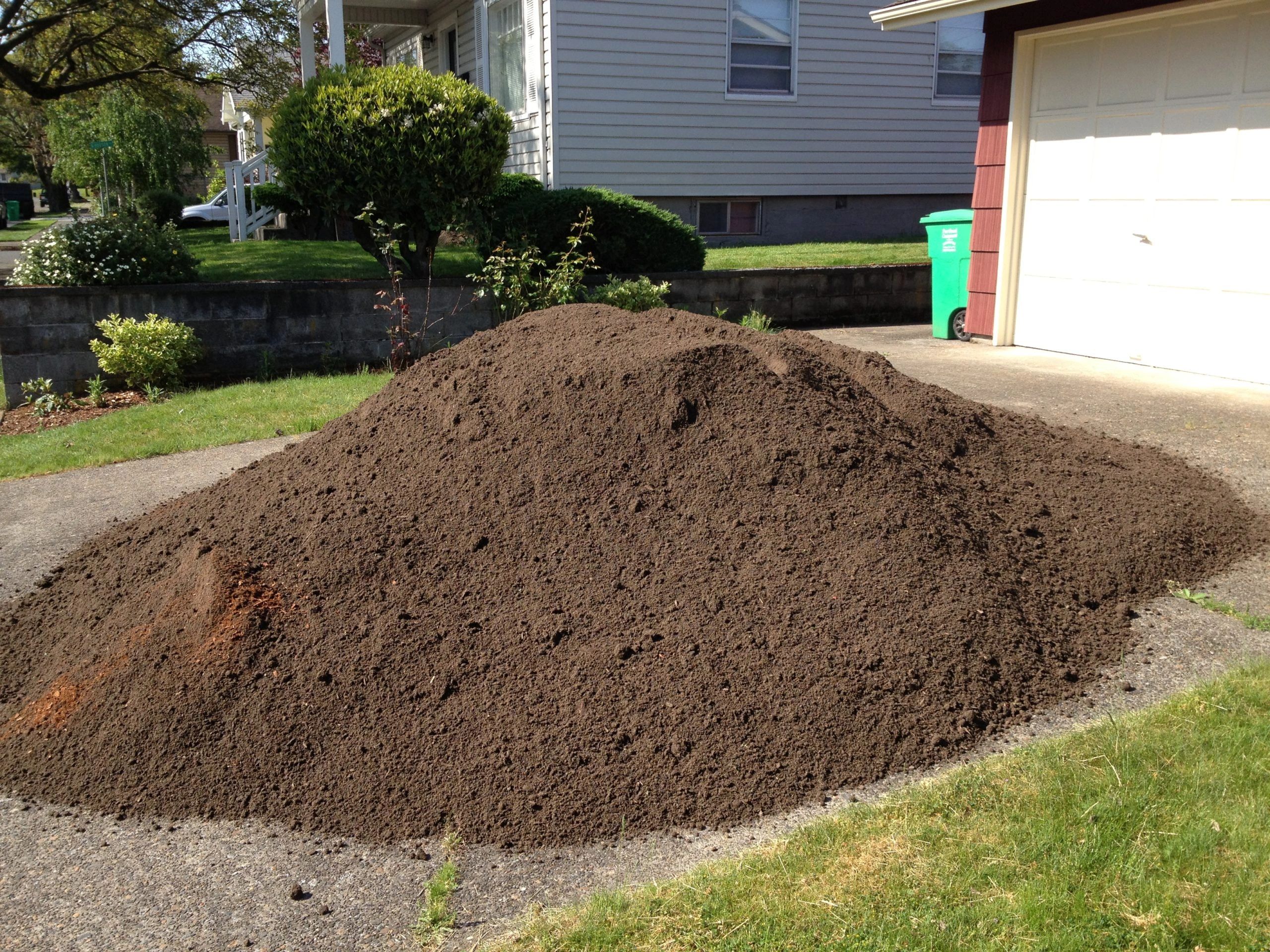 rock and dirt removal in colorado springs - a pile of dirt in the driveway about to be removed
