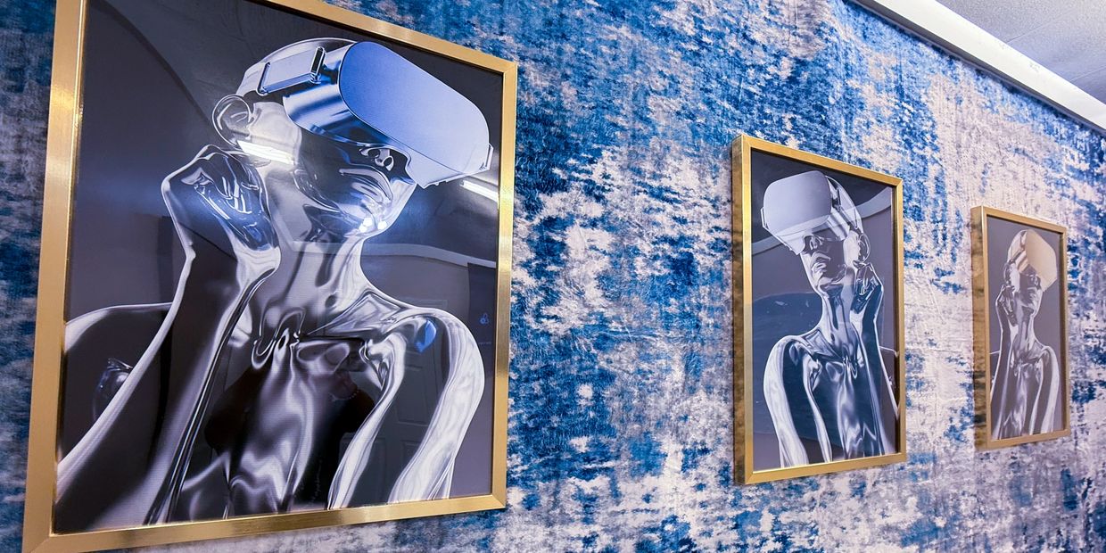 Three framed futuristic portraits of a figure wearing VR headsets on a textured blue wall.