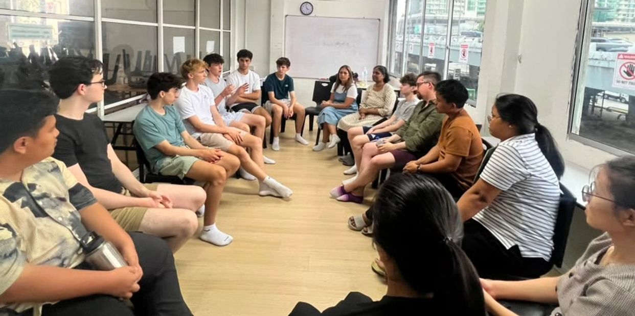 Group discussion with people seated in a circle indoors.
