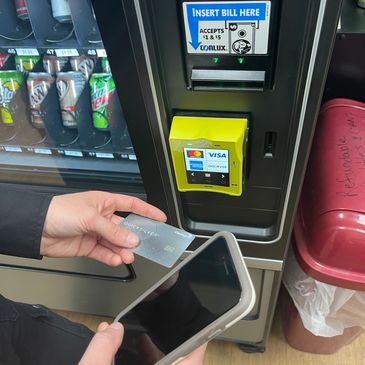 Person using a major credit card at vending machine.