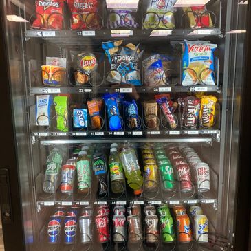 Vending machine stocked with a wide variety of drinks and snacks.