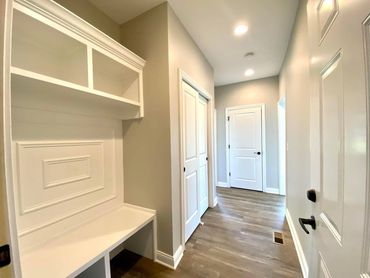 Bright hallway with white doors and built-in storage bench.